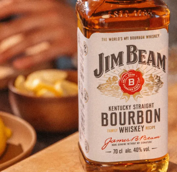 Jim beam bottle placed on table with fruits in background