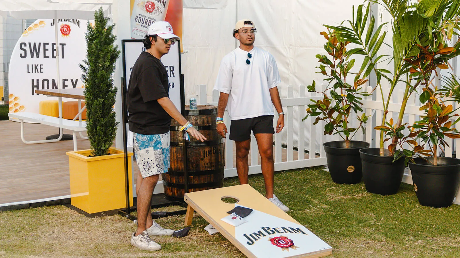 Friends playing cornhole game at Gulf Coast Jam 2024