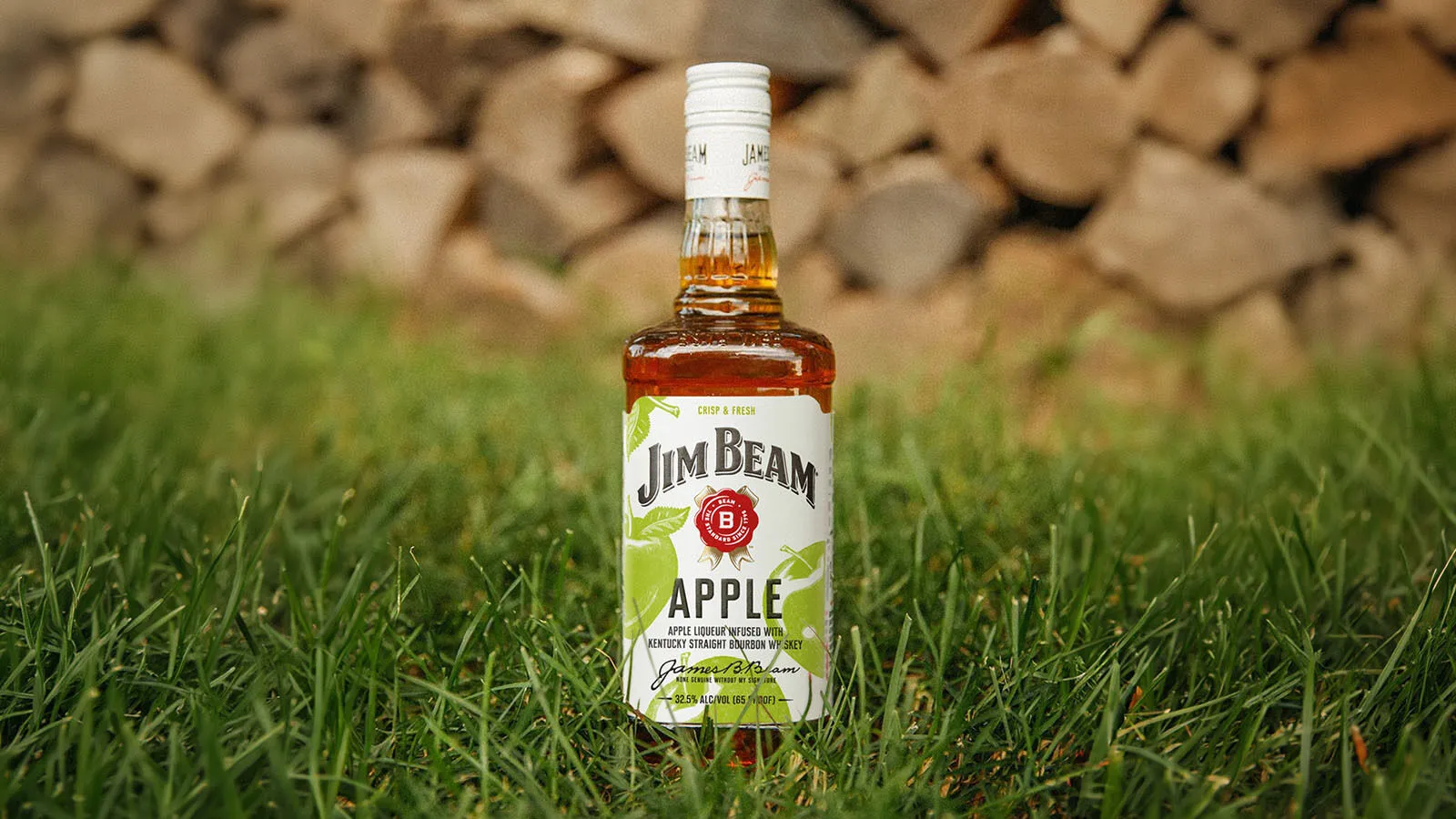A bottle of jimbeam pineapple placed on the grass
