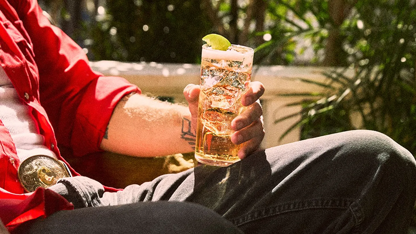 Bourbon whiskey glass in hand background Image