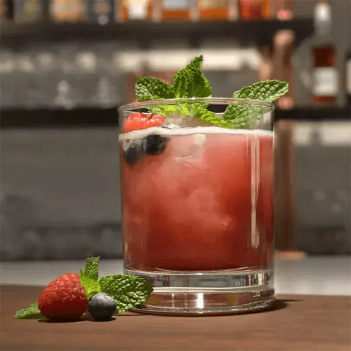 A glass of beam berry julep garnish with mint